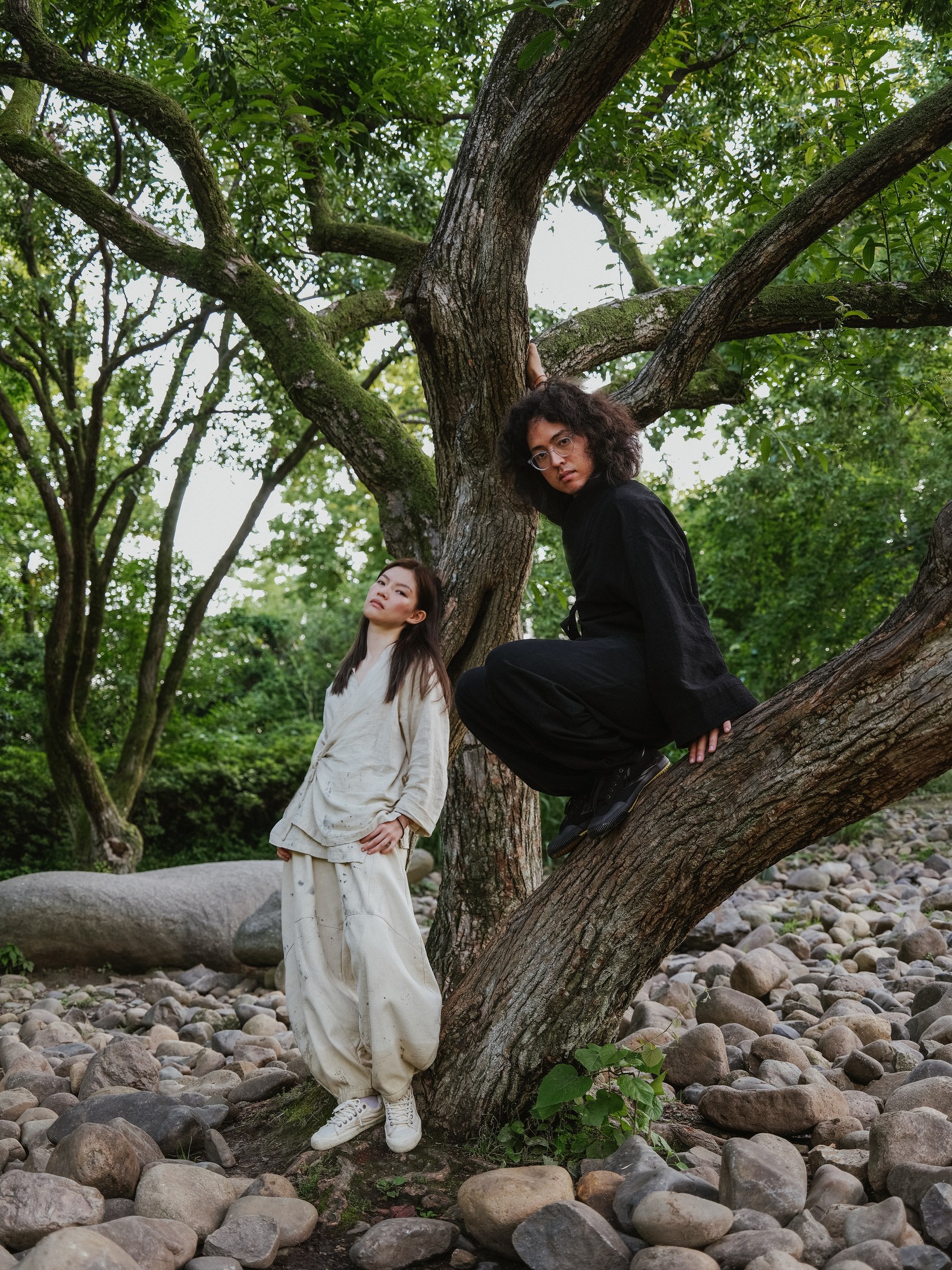 JUHNZ artist Junie Xia and musician Milam together beneath a tree